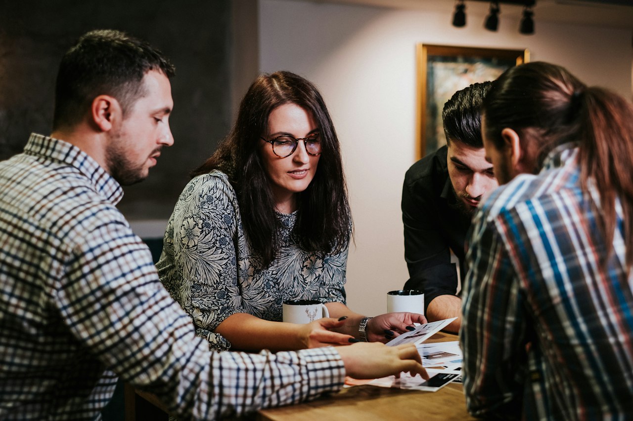 Four people going through year-end figures together at a meeting table
