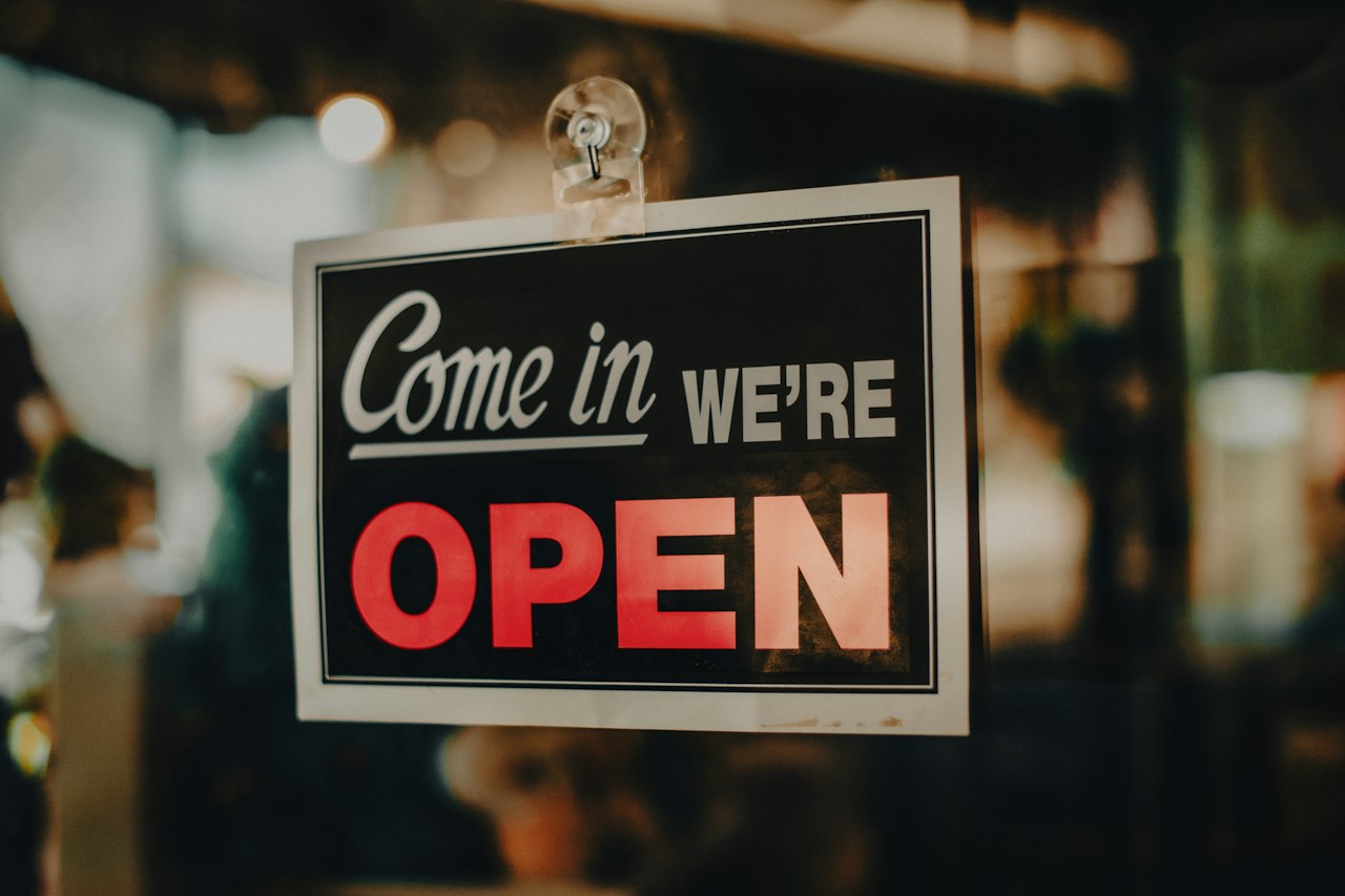 An open sign in the window of a newly opened business
